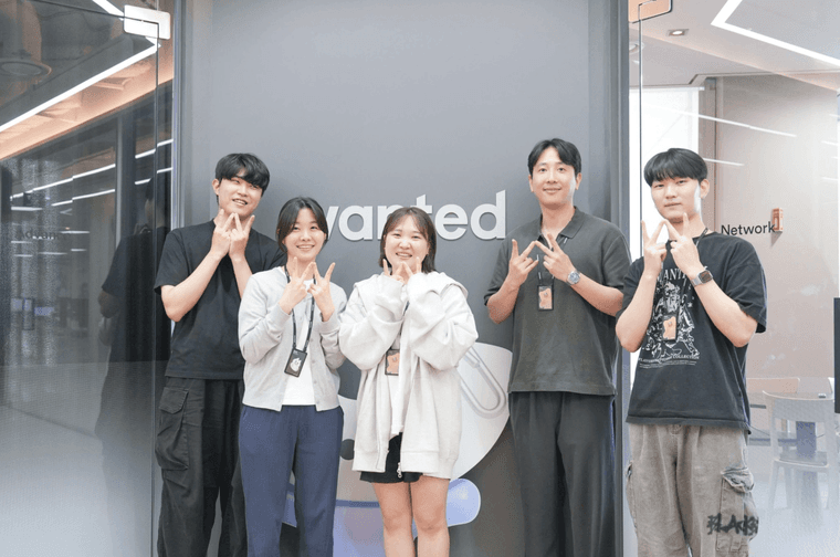 포지션 맵 팀이 원티드 사인 앞에서 포즈를 취한 모습